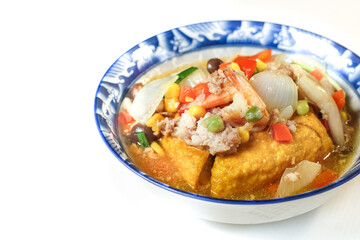 Fried tofu topped with minced pork, shrimp, and nutritious vegetables. An easy to make ancient Chinese dish. Asian food on white background.