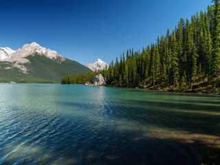 Clear turquoise waters of Maligne Lake in Jasper National Park, Alberta. Snow-capped Rocky...