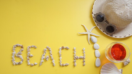 Flat lay of cold refreshing beverage, a starfish, white pebbles, straw summer hat, sunglasses, and...