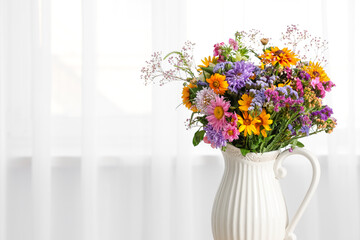 Vase with wild flowers near light curtains in room. Closeup