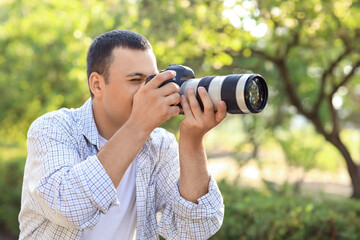 Male photographer with modern camera outdoors