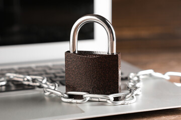 Padlock with chain on laptop, closeup. Cyber security concept