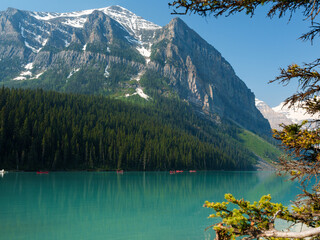 Scenic view of Lake Louise with turquoise waters and mountain backdrop on a sunny summer day in Banff National Park, Alberta, Canada.