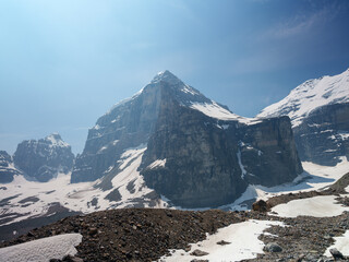 Sharp rocky summit covered with snow under clear blue sky in Canadian Rockies. Remote alpine scene...