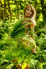 Nude woman in fern in forest
