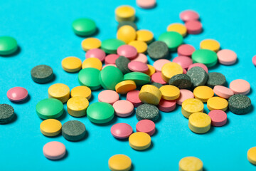 Colorful pills on blue background, closeup
