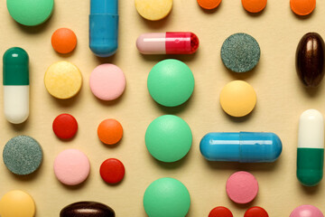 Different colorful pills on beige background