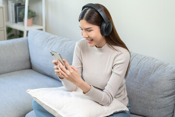 Relaxing asian young woman using smart phone listening to music, enjoy song or watching videos,...