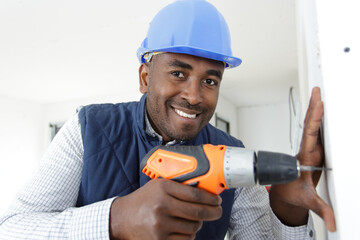 man drills into wall with a power tool