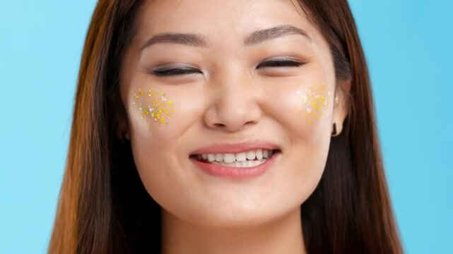closeup portrait of a woman with colorful polka dot makeup smilin