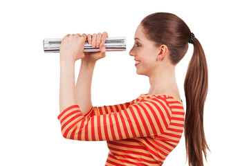 Woman looks in the magazine folded, like a telescope.