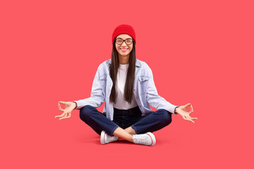 Young woman meditating on red background