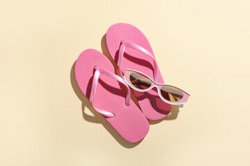 Composition with flip-flops and sunglasses on beige background