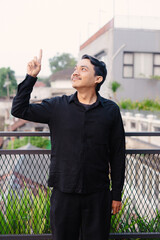 Upward gaze and raised index finger against an urban backdrop: concept and direction