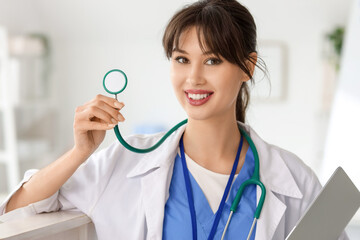 Female medical intern with stethoscope and laptop in clinic, closeup