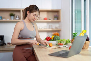 Wellness and Meal Preparation. Young woman chopping vegetables in a bright kitchen.