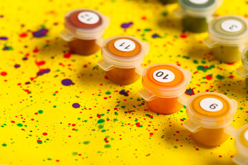 Set of cans with paints on canvas with abstract painting