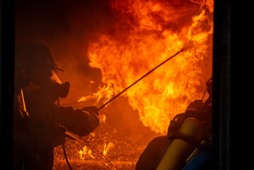 Firefighter Rescue team training fire fighting extinguisher. Teamwork Firefighter fighting with...