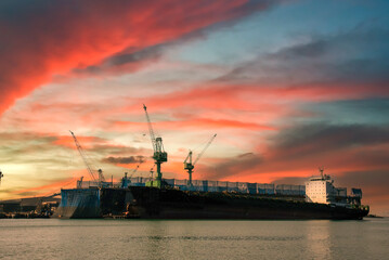 Fototapeta premium Industry landscape on sunset Engineering shipping crane depot at logistic export terminal control. Silhouette Warehouse freight background container yard loading quayside harbor port with copyspace