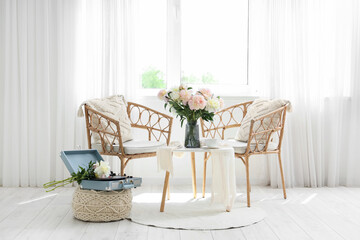 Interior of stylish room with chairs, table, record player and beautiful peonies
