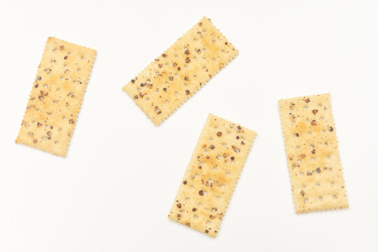 Four pieces of black truffle ham soda biscuits on a white surface.