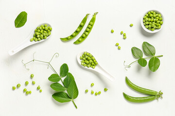 Spoons and bowl with fresh green peas on white background