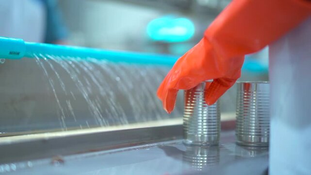 Unrecognizable canning workers are working in canned fish factory.