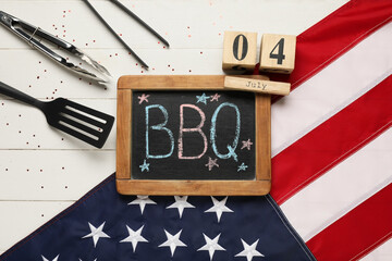 USA flag, chalkboard with word BBQ, calendar with date 04 JULY and barbecue utensils on white...