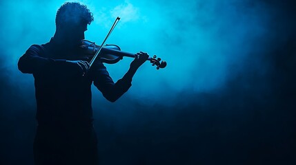 Fototapeta premium Man Playing Violin Silhouette against Blue Smoke Background in Dramatic Lighting