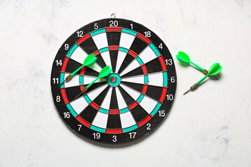 Board with darts on light background