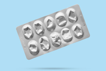 Empty medicine aluminium foil silver blister packaging isolated on blue background