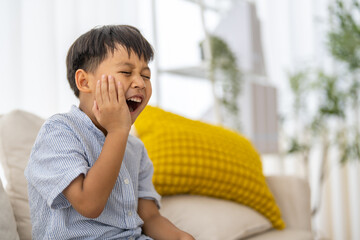Young child experiencing toothache, tooth decay, childhood dental pain. The child facial...