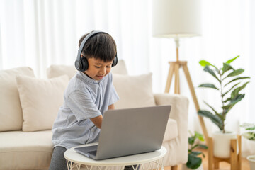 Asian boy using laptop with headphones course online learning, distance education for kids,...
