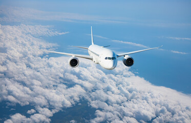 White passenger airplane flying in the sky amazing clouds in the background - Travel by air...