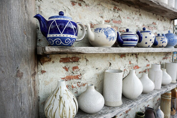 Ceramic products such as vases, glass bottles, teapots, placed on shelves