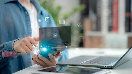 Close-up of a person using smartphone to watch online learning video, with digital education icons floating, symbolizing e-learning, remote study, virtual training, and smart education technology.