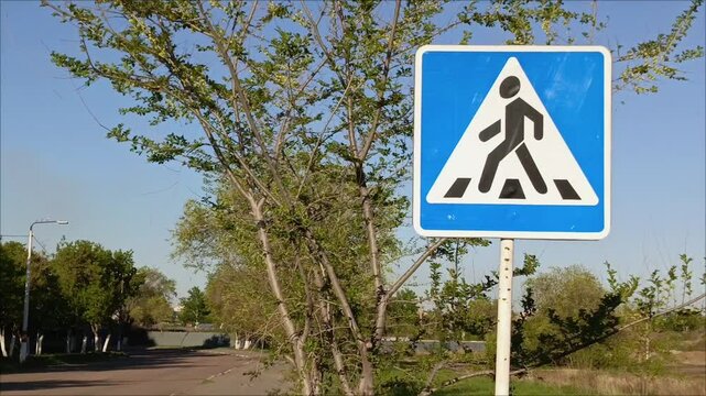 A pedestrian crossing sign on the road in close-up. Traffic Laws.