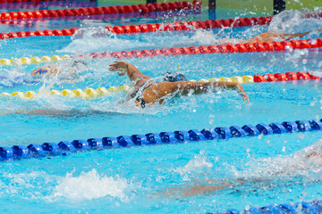 Swimmer child swims butterfly swimming style in a race swimming pool. Water sports and competition,...