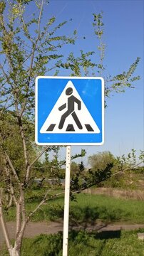 A pedestrian crossing sign on the road in close-up. Traffic Laws.