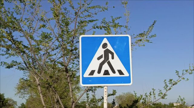A pedestrian crossing sign on the road in close-up. Traffic Laws.