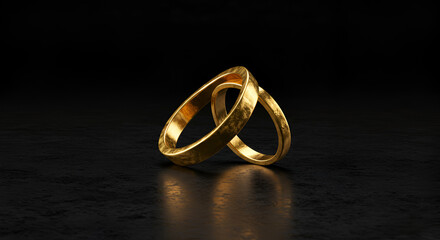 Two golden rings intertwined on dark surface
