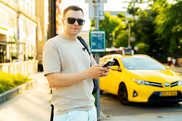 Man with Smartphone Waiting for Taxi in the City