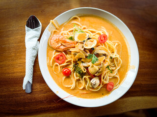 Delicious Seafood Pasta in Creamy Sauce Served on a Traditional Wooden Table