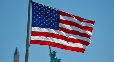 The American flag waving proudly against a clear, bright blue sky, with monuments in the background.