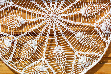 A white lace doily with a pattern of leaves and flowers