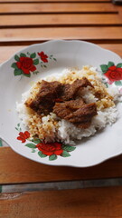 eating rendang in front of the house