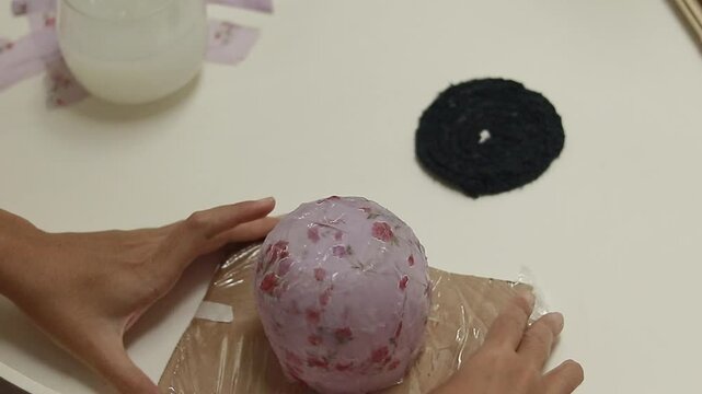 Showing a finished craft project using cornstarch glue and recycled fabric to create a decoupage container