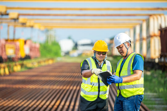 Railway project supervisor reviewing project on tablet, team railway project planning worker at construction site look tablet checking railway project by supervisors Infrastructure Team Coordinating