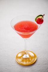 A refreshing red cocktail garnished with a cherry and lime wedge. Perfect for a summer party.