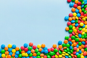 Mixed collection of colorful candy, on colored background. Flat lay, top view. frame of colorful chocolate coated candy
